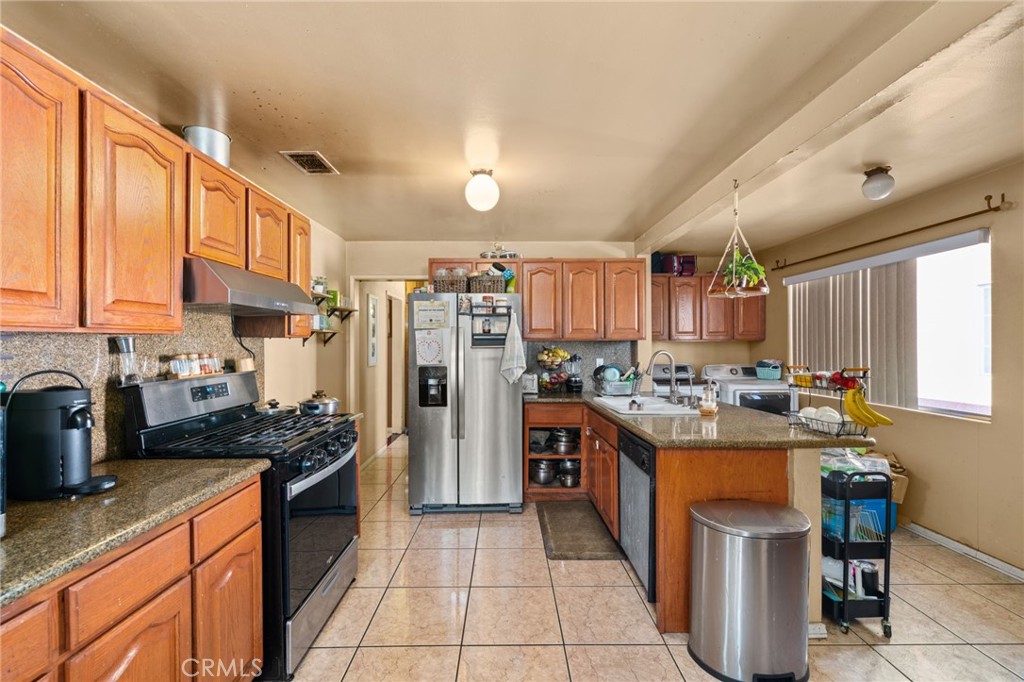 15355 Eucalyptus Avenue Bellflower, CA 90706 - Photo 7 of 20 a kitchen with lots of counter top space stove and cabinets