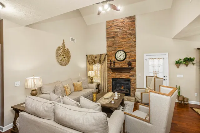 a living room with furniture a fireplace and wooden floor