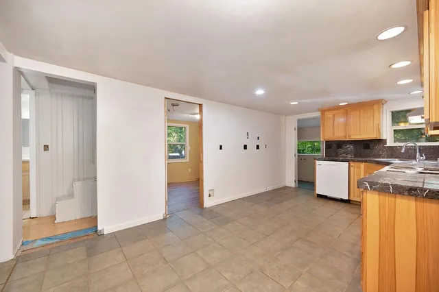 a view of a house with a small yard and wooden fence