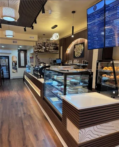 a view of living room kitchen with stainless steel appliances wooden floor