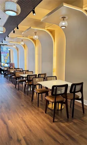 a dining hall with furniture wooden floor and a rug