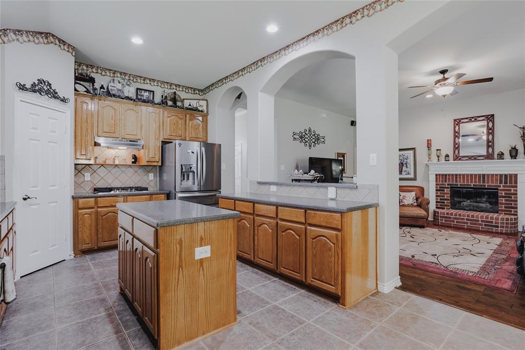 2314 Ranch Road Sachse, TX 75048 - Photo 12 of 27 Kitchen featuring light wood cabinetry, stone-finish countertops, and a tiled backsplash
