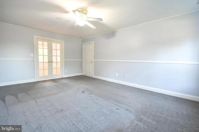 an empty room with a window and a ceiling fan