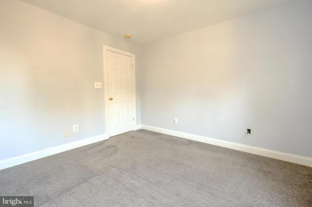 an empty room with kitchen and windows