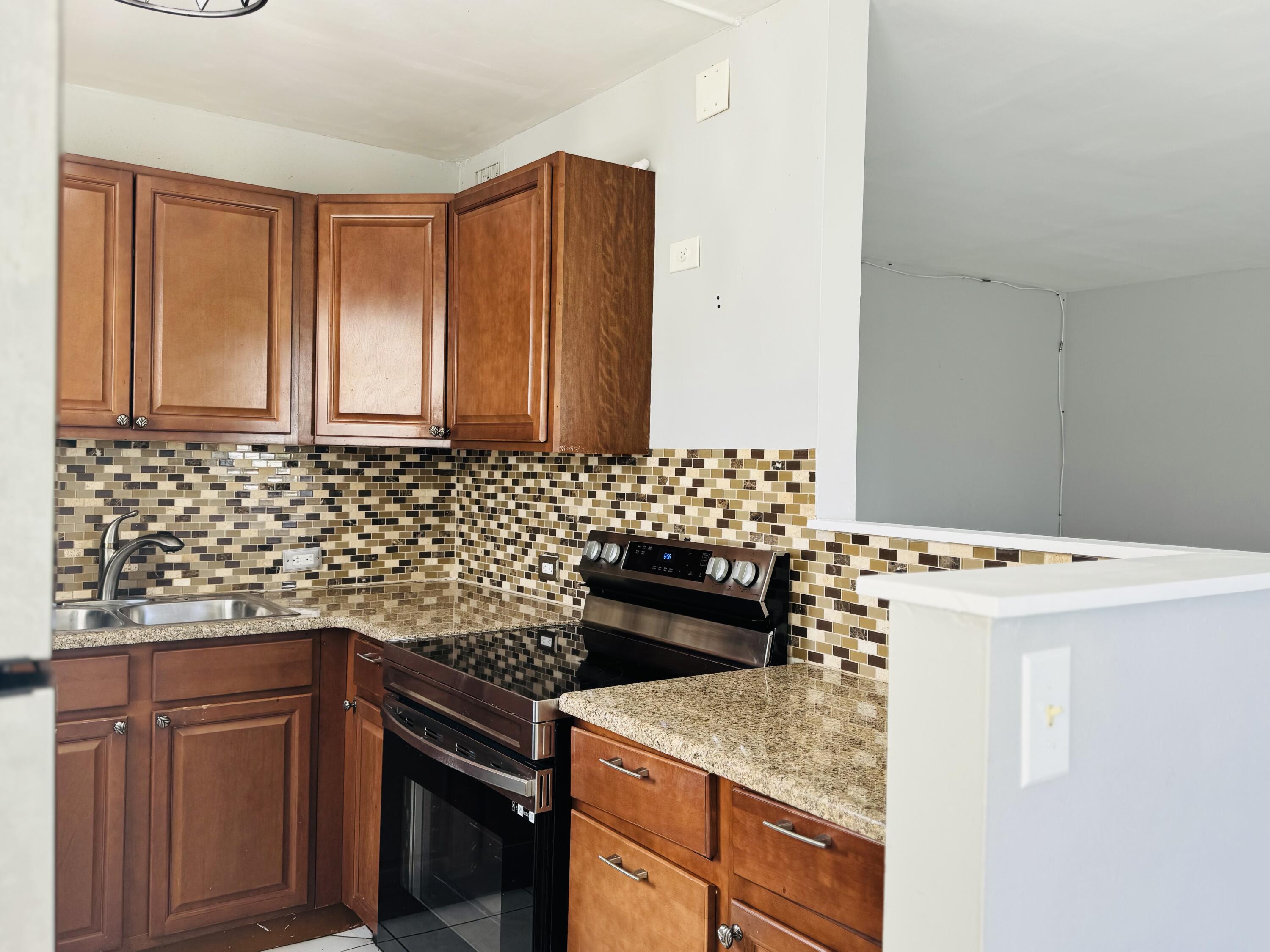 a kitchen with stainless steel appliances granite countertop cabinets and a stove top oven