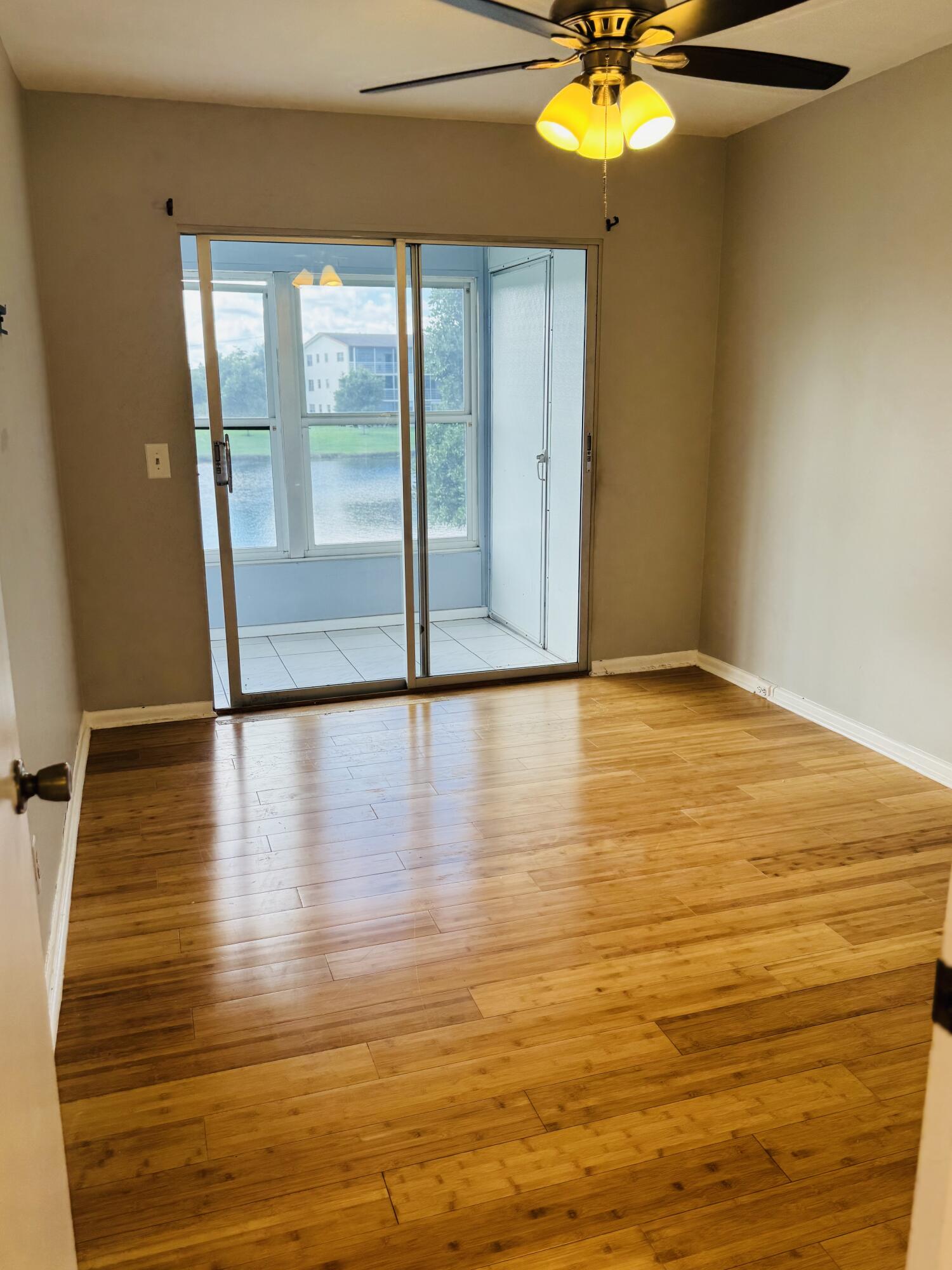 151 Brighton Drive, Unit D Boca Raton, FL 33434 - Photo 14 of 29 a view of empty room with wooden floor and fan