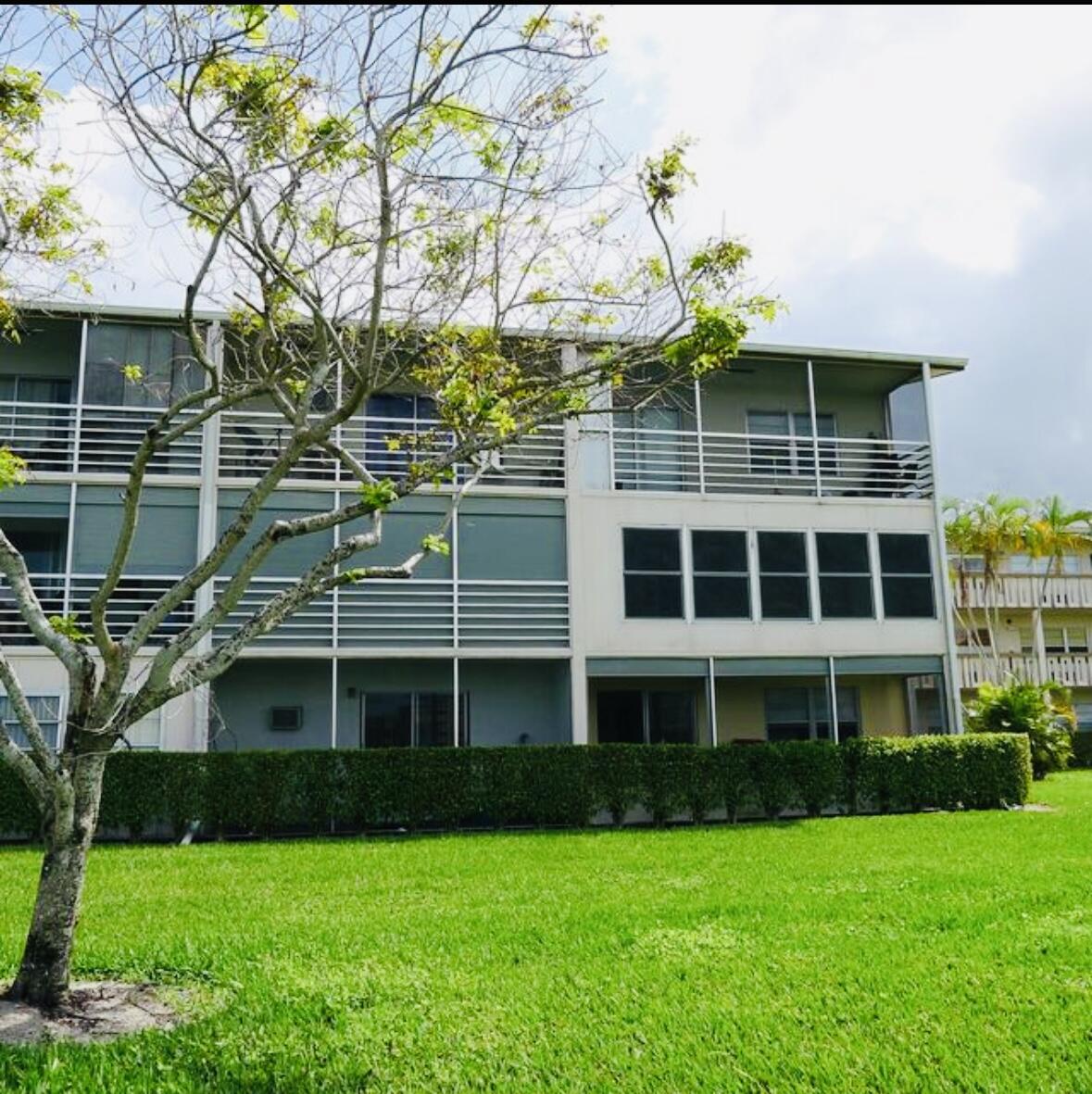 151 Brighton Drive, Unit D Boca Raton, FL 33434 - Photo 28 of 29 a front view of a building with a garden