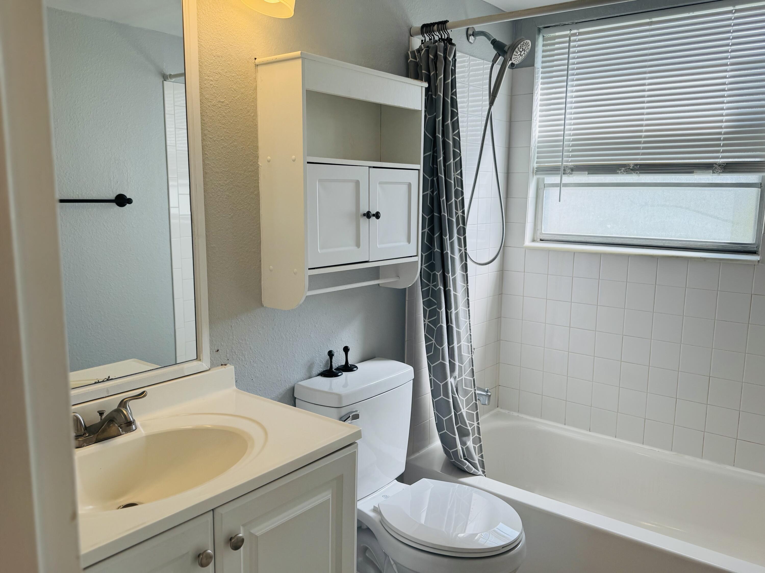 151 Brighton Drive, Unit D Boca Raton, FL 33434 - Photo 10 of 29 a bathroom with a sink toilet and shower