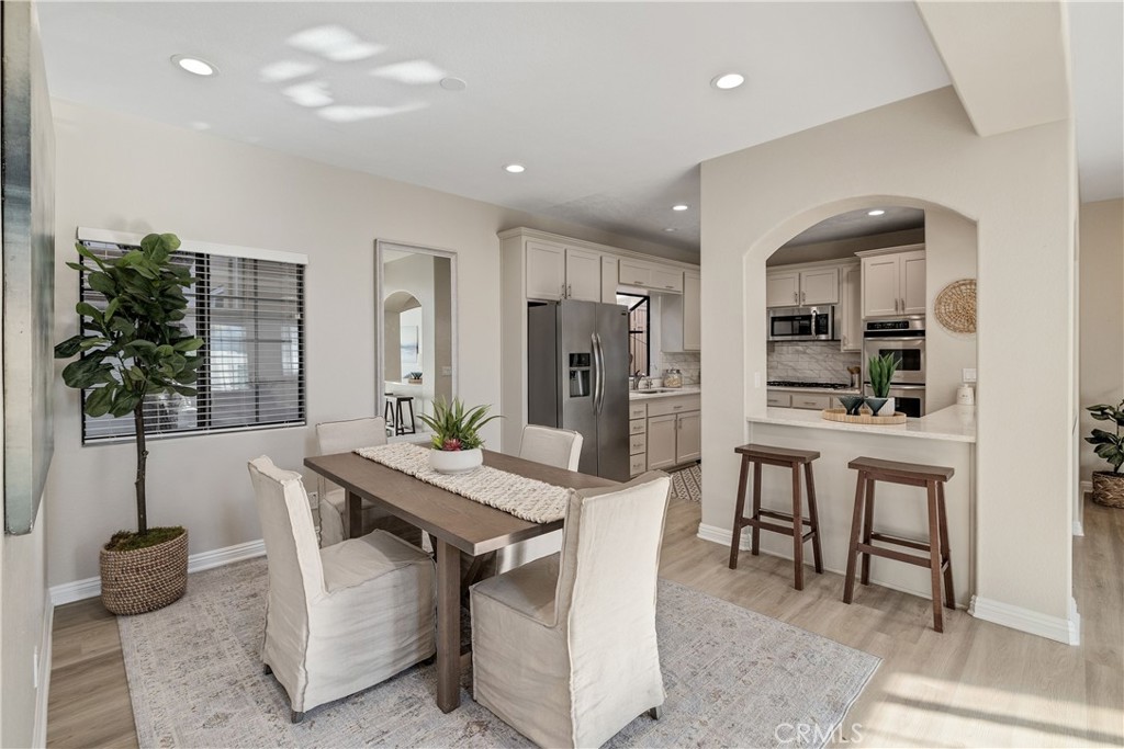 750 14th Street Manhattan Beach, CA 90266 - Photo 22 of 60 a kitchen with stainless steel appliances kitchen island granite countertop a table chairs in it and white cabinets