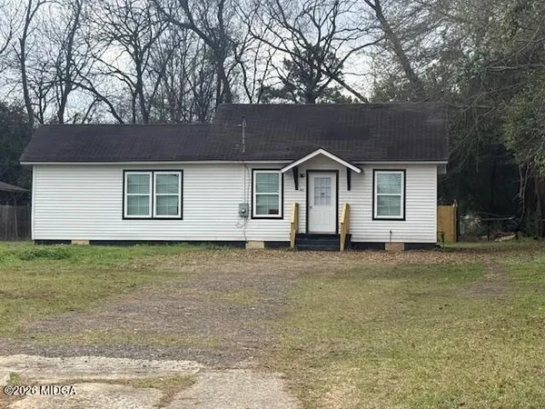 a front view of a house with a garden