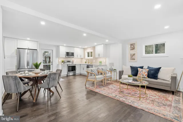 a living room with furniture wooden floor and kitchen view