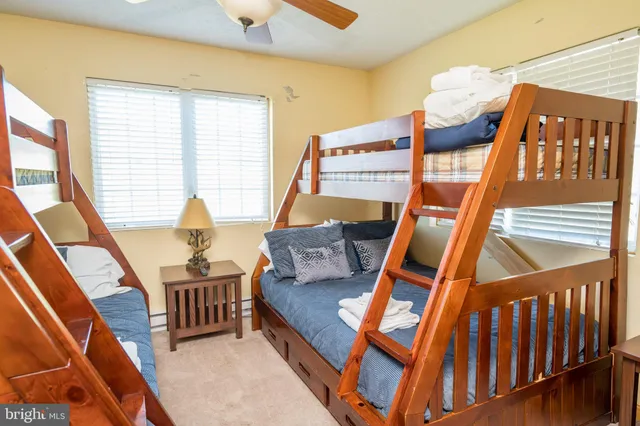 a bedroom with a bed and a dresser with wooden floor
