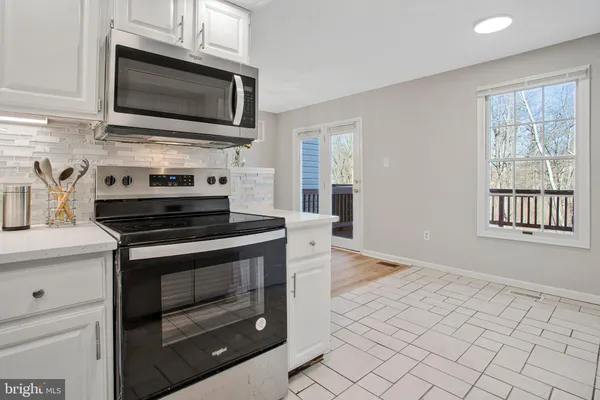 a kitchen with cabinets appliances and a window