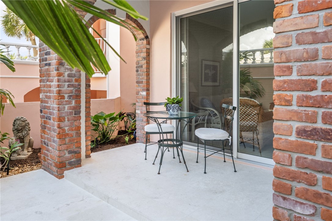 1050 Reef Road, Unit 102 Vero Beach, FL 32963 - Photo 18 of 36 a view of a patio with a table and chairs and potted plants
