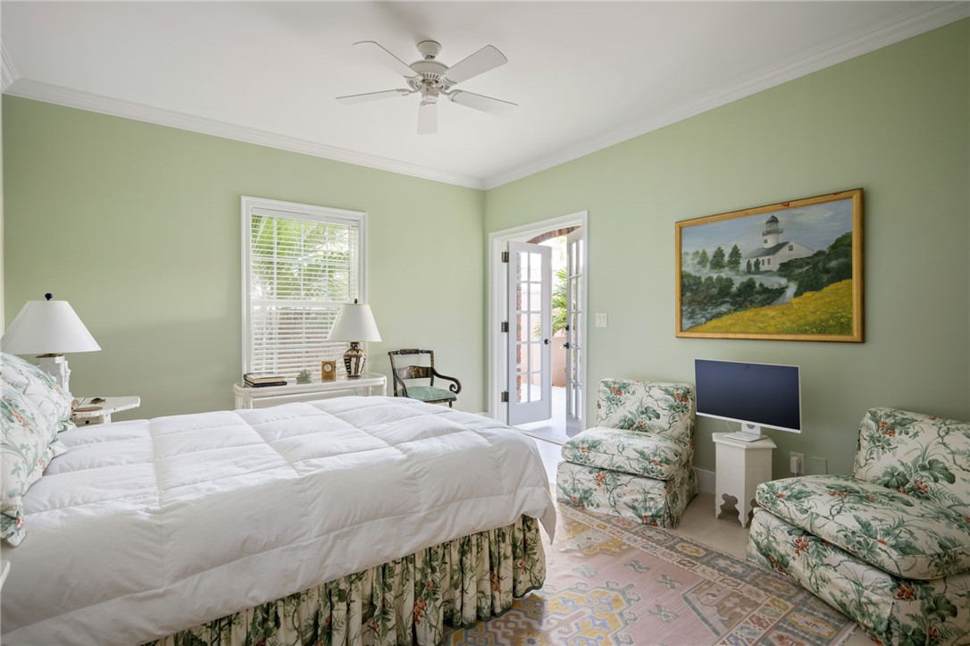1050 Reef Road, Unit 102 Vero Beach, FL 32963 - Photo 21 of 36 a bedroom with a bed a couch and potted plant on the dresser
