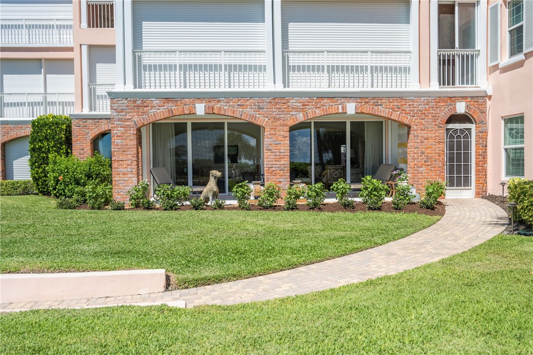 1050 Reef Road, Unit 102 Vero Beach, FL 32963 - Photo 23 of 36 a view of a brick house with a yard and plants