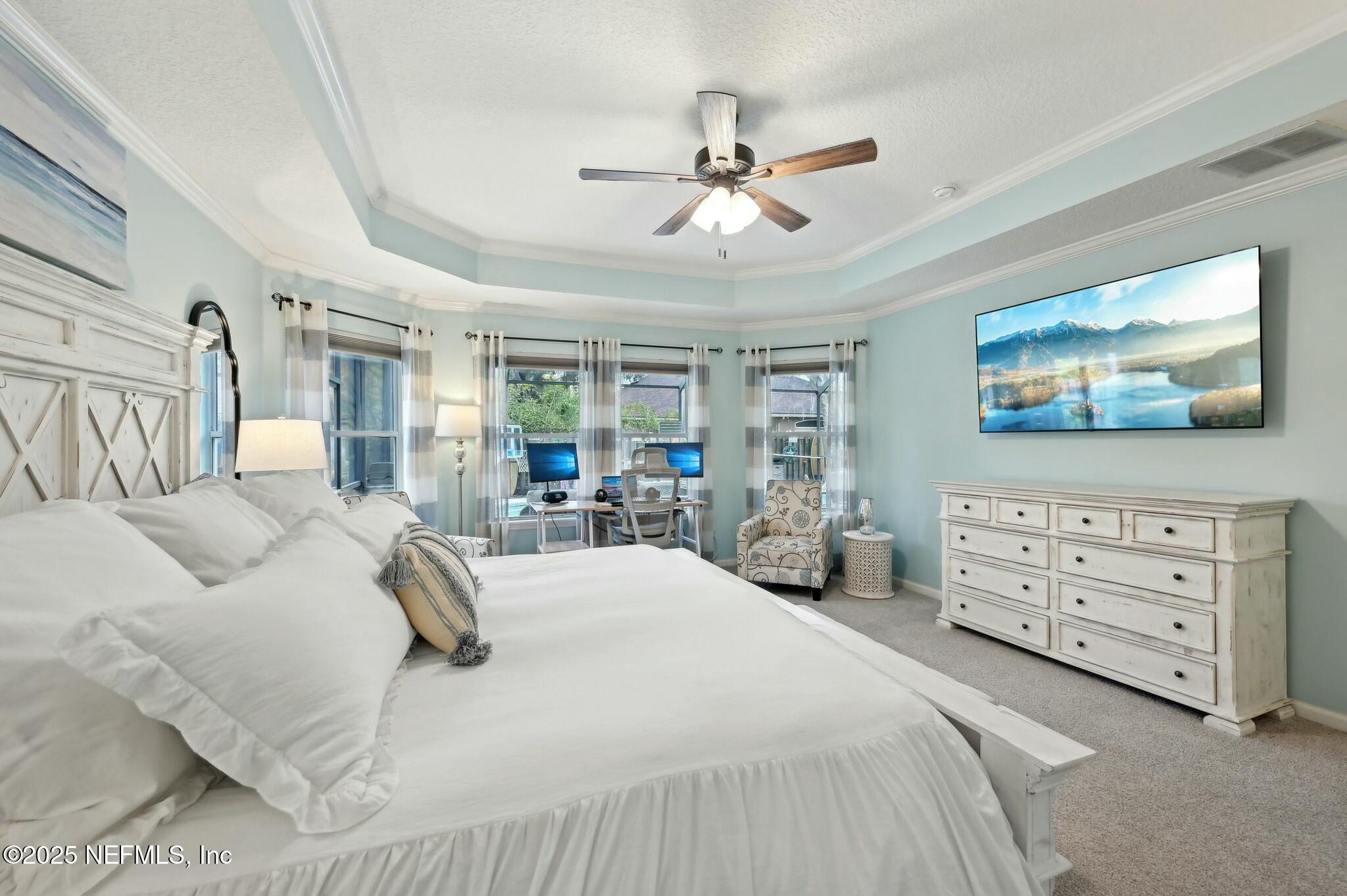 1732 Margarets Walk Road Fleming Island, FL 32003 - Photo 23 of 55 a bedroom with a bed a chandelier and a dresser
