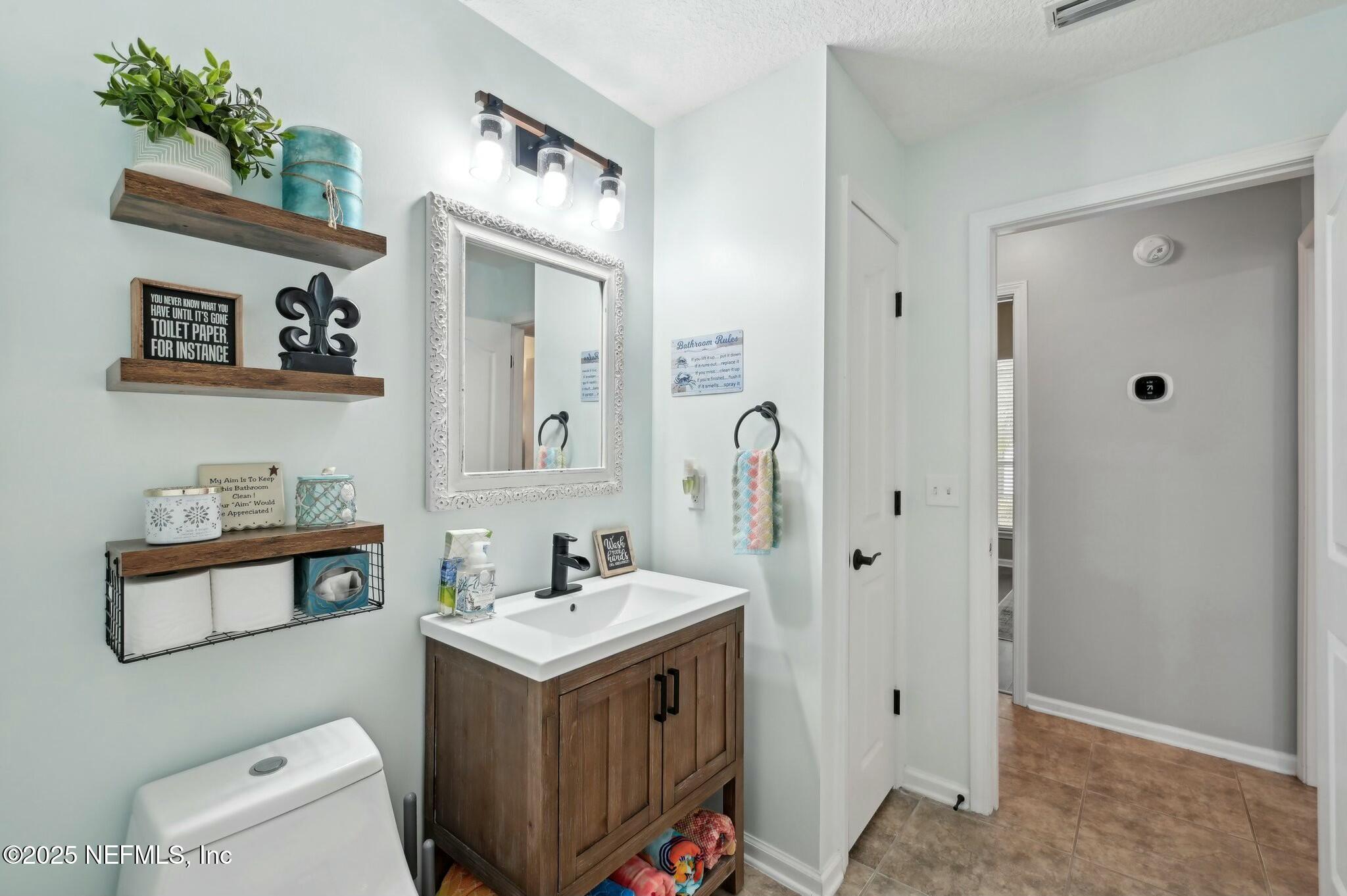 1732 Margarets Walk Road Fleming Island, FL 32003 - Photo 40 of 55 a bathroom with a sink a mirror and a toilet