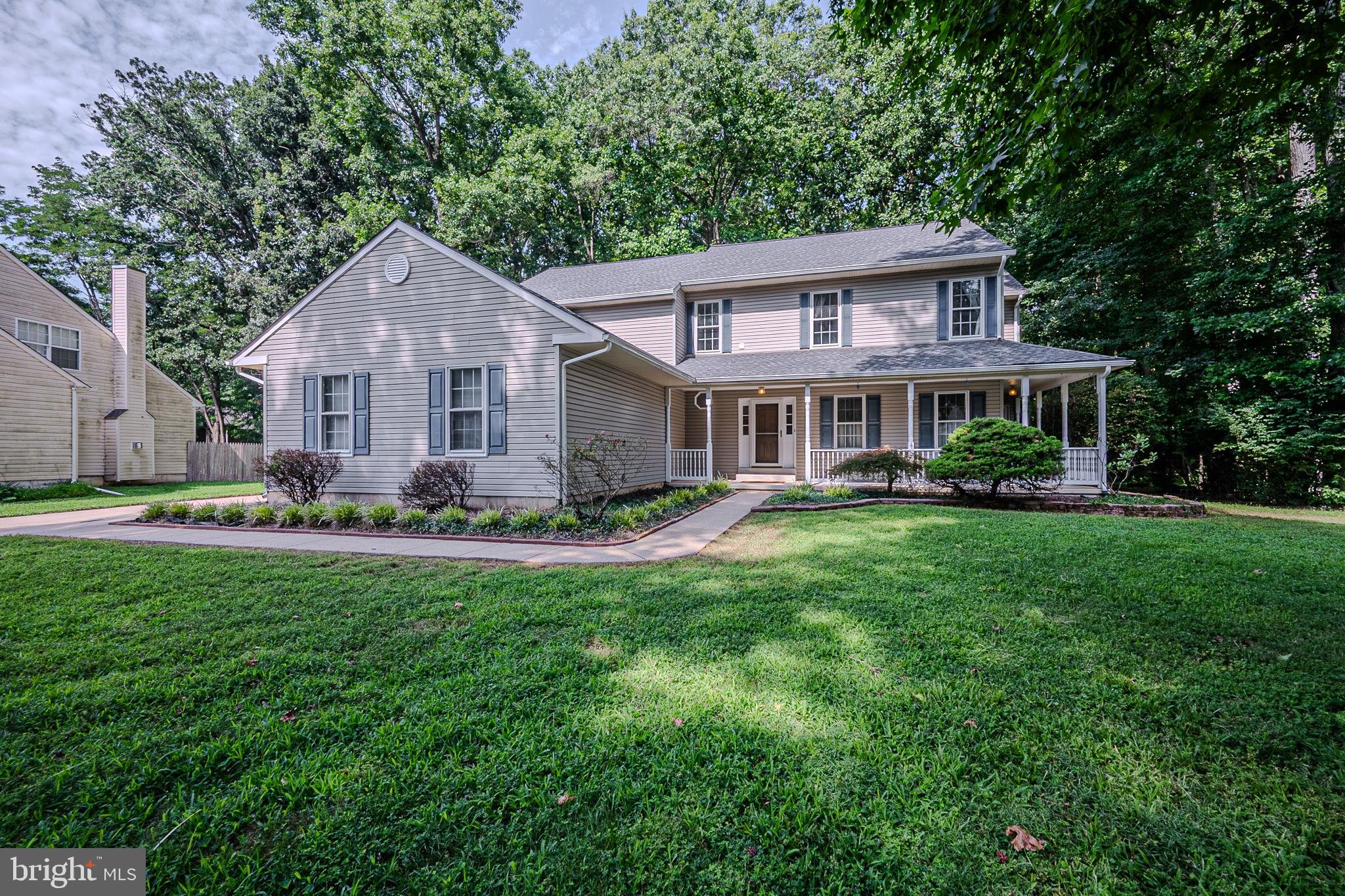 a front view of a house with a yard and green space