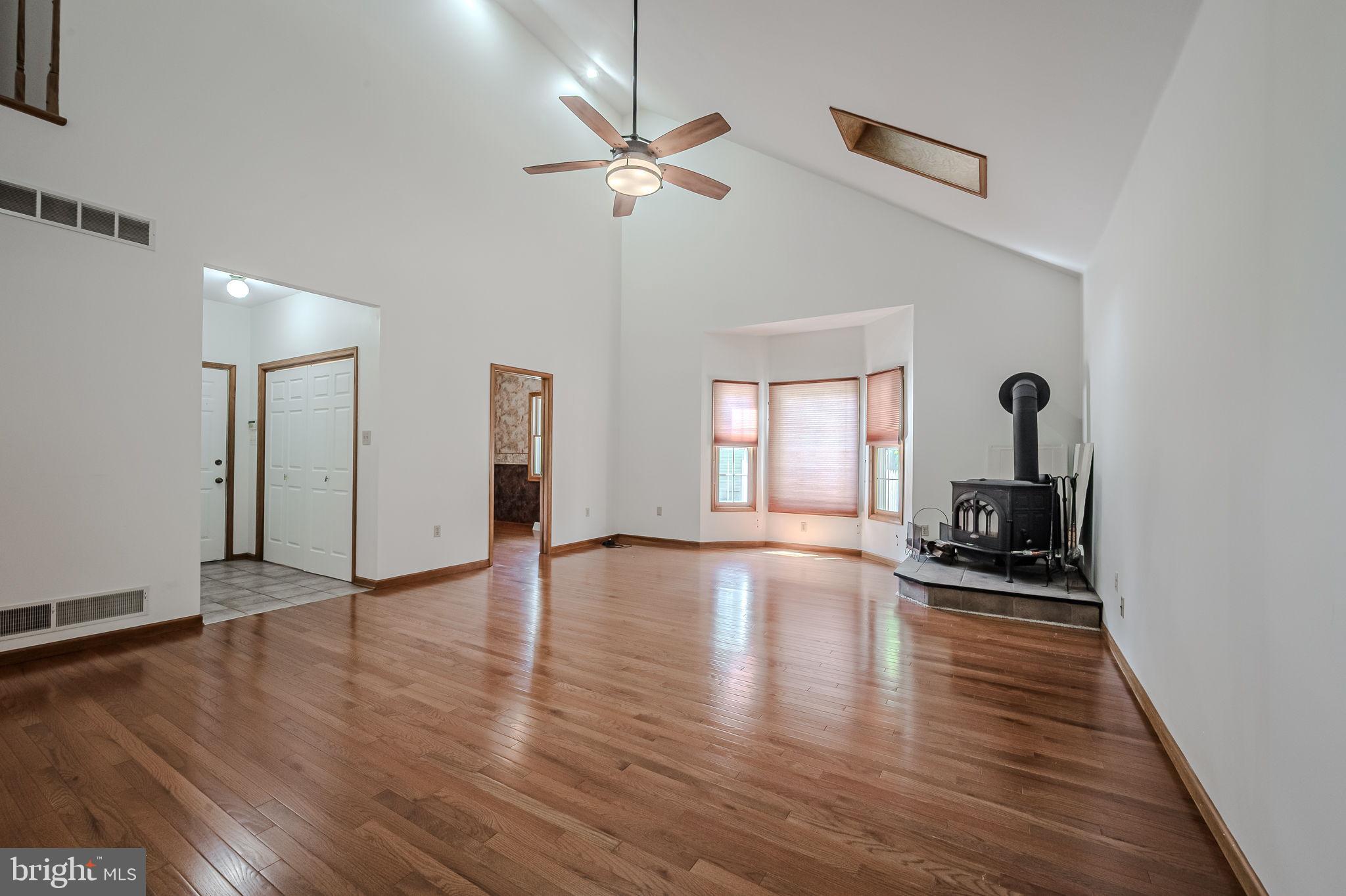 108 Michaels Lane Newark, DE 19713 - Photo 25 of 53 a view of a livingroom with wooden floor a ceiling fan and windows