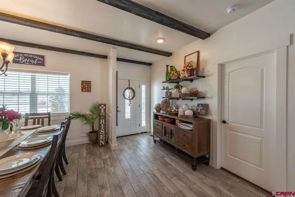 a dining room with wooden floor a chandelier a wooden table and chairs