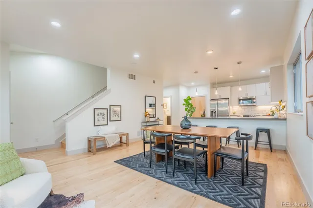 a kitchen with kitchen island a counter top space a stove a refrigerator and a sink