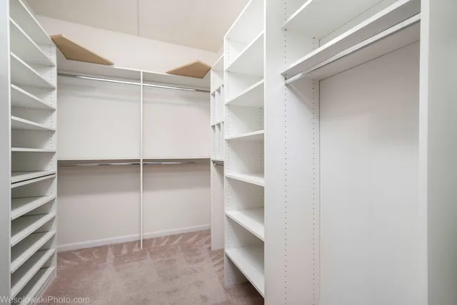 a view of walk in closet with empty racks