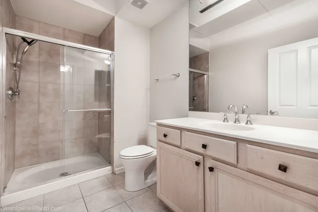 a bathroom with a shower sink vanity mirror and toilet