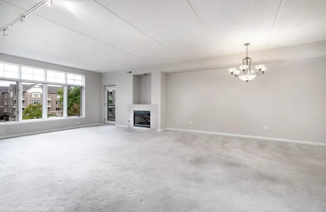 a view of empty room with fireplace and large windows