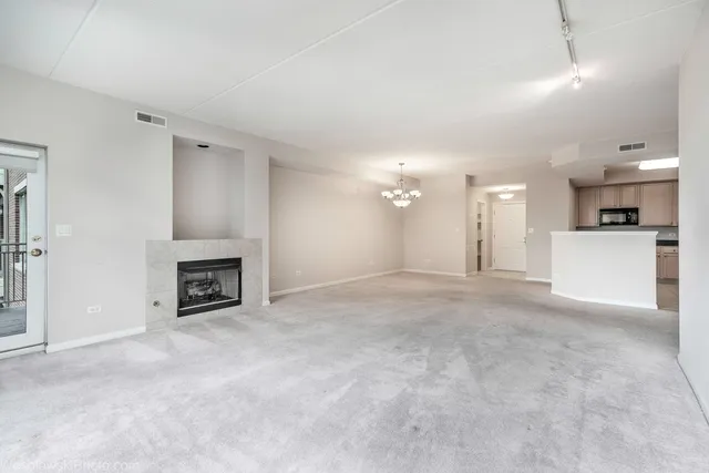 an empty room with fireplace and windows