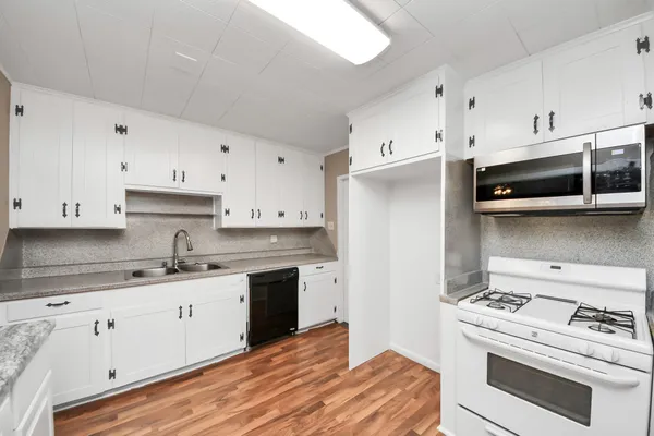 a kitchen with a sink a stove and cabinets