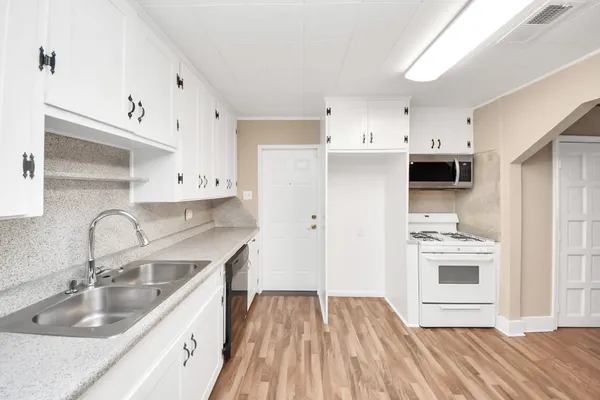a view of an empty room with a kitchen
