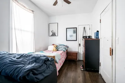 a bedroom with a bed and wooden floor