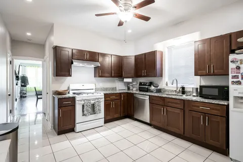 a kitchen with stainless steel appliances granite countertop a stove cabinets a sink and a refrigerator