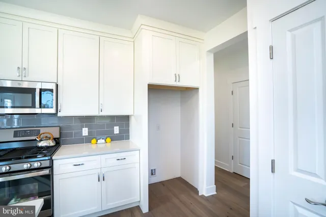 a view of empty room with wooden floor and ceiling fan