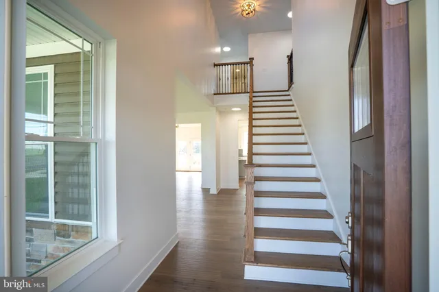 an empty room with windows a fireplace and wooden floor
