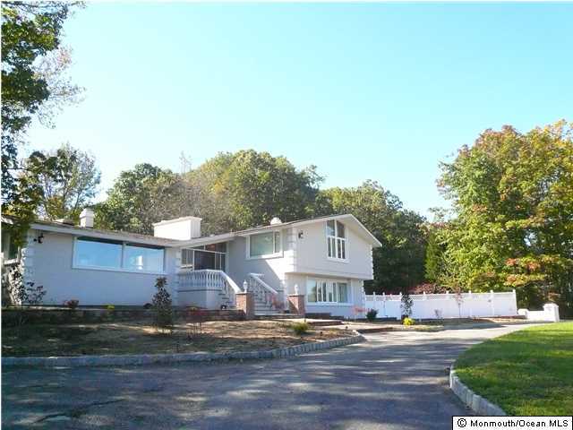 127 Stone Hill Road Colts Neck, NJ 07722 - Photo 2 of 7 a front view of a house with garden