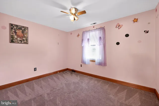 an empty room with windows and a ceiling fan