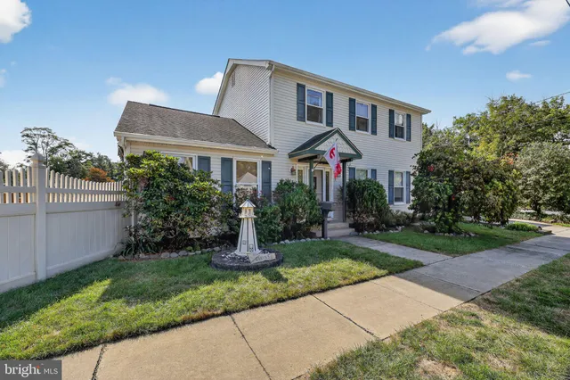 a front view of a house with a yard and potted plants