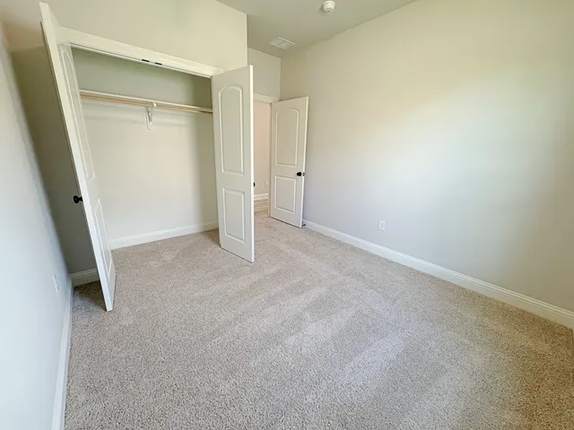 an empty room with closet and mirror
