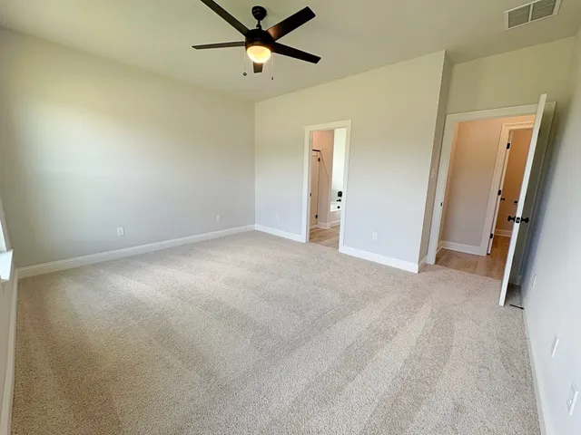 an empty room with a ceiling fan and window
