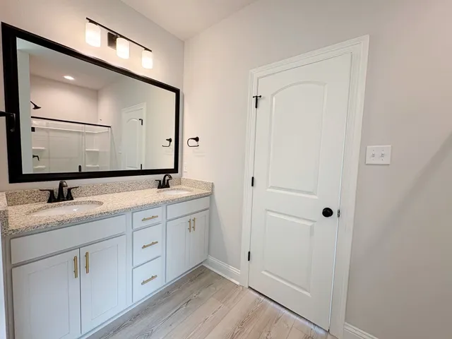 a bathroom with a double vanity sink and a mirror