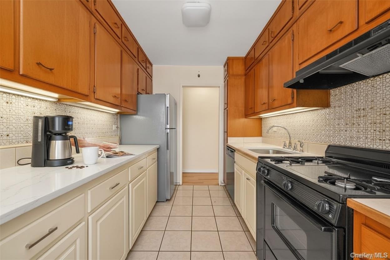 99-10 60th Avenue, Unit 5D Queens, NY 11368 - Photo 3 of 9 a kitchen with stainless steel appliances granite countertop a stove a sink and a refrigerator