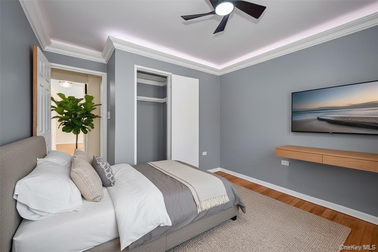 99-10 60th Avenue, Unit 5D Queens, NY 11368 - Photo 5 of 9 a bedroom with a large bed and a chandelier