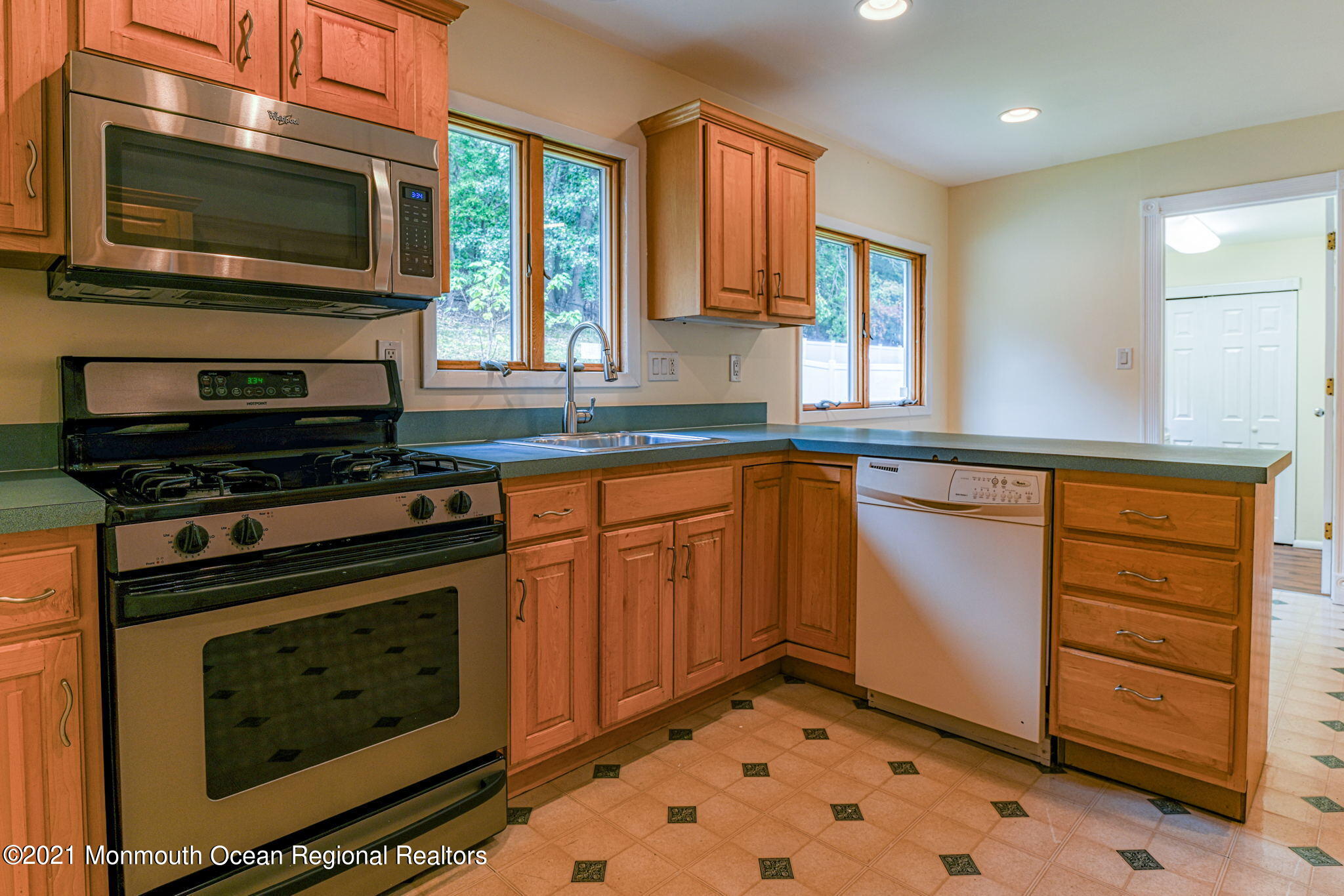 56 Newbury Road Howell, NJ 07731 - Photo 12 of 32 a kitchen with granite countertop a stove top oven microwave and cabinets