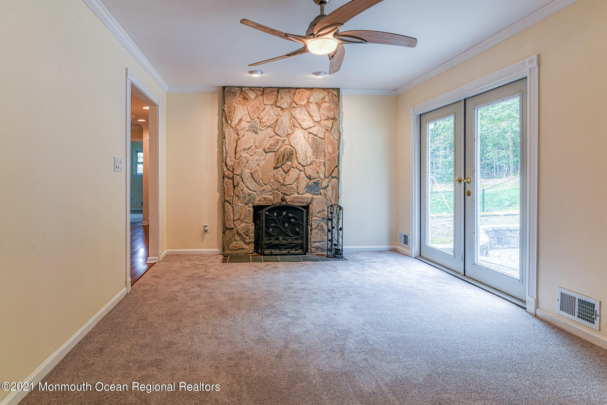 56 Newbury Road Howell, NJ 07731 - Photo 9 of 32 an empty room with windows a fireplace and a chandelier fan