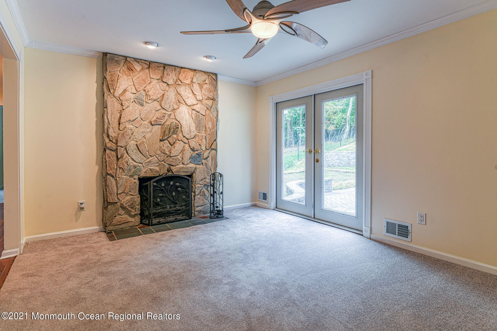 56 Newbury Road Howell, NJ 07731 - Photo 10 of 32 an empty room with windows a fireplace and a chandelier fan