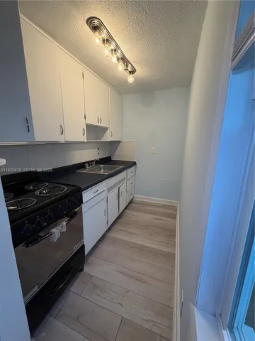 a kitchen with a stove and white cabinets