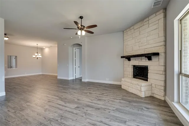 a view of an empty room with a fireplace and a window