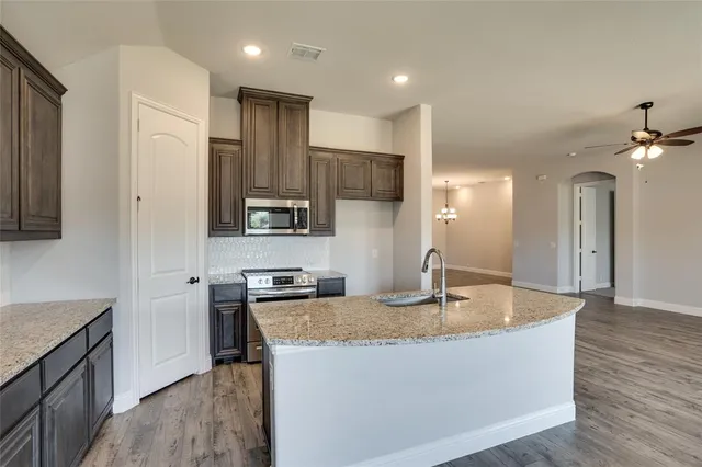 a kitchen with a sink dishwasher a stove and a refrigerator with wooden floor